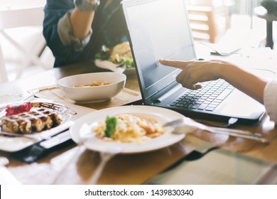 Group of Friends are during meal in cafe. Crop young people sitting at restaurant using laptop computer. - Shutterstock ID 1439830340
