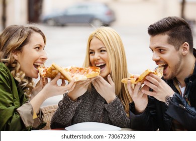 Group Of Friends Eating Pizza In A Restaurant. 