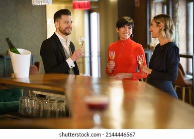 Group of friends in elegant clothes toasting with glasses of champagne while celebrating holiday together in luxury bar - Shutterstock ID 2144446567