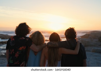 group of friends embrace on beach looking at beautiful sunset enjoying summer vacation lifestyle - Powered by Shutterstock