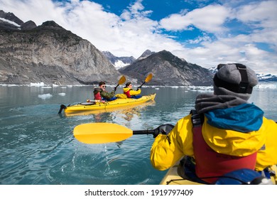 Group of friends enjoy ocean kayaking bear glacier during their vacation trip to in Alaska, USA 