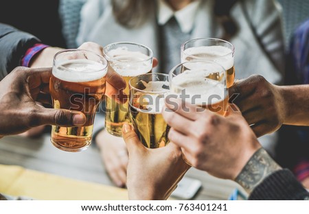 Group of friends enjoying a beer in brewery pub - Young people hands cheering at bar restaurant - Friendship and youth concept - Warm vintage filter - Main focus on bottom hand