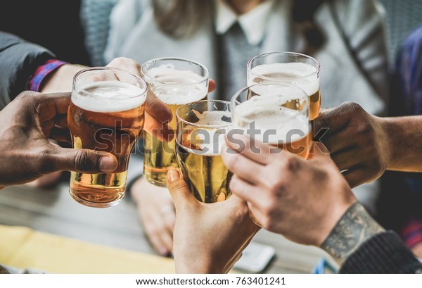Group of\
friends enjoying a beer in brewery pub - Young people hands\
cheering at bar restaurant - Friendship and youth concept - Warm\
vintage filter - Main focus on bottom\
hand