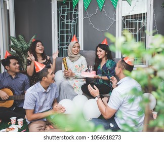 Group of friends enjoying brithday party and singing together - Shutterstock ID 1056518273