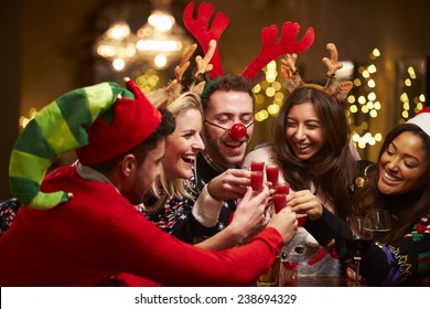 Group Of Friends Enjoying Christmas Drinks In Bar