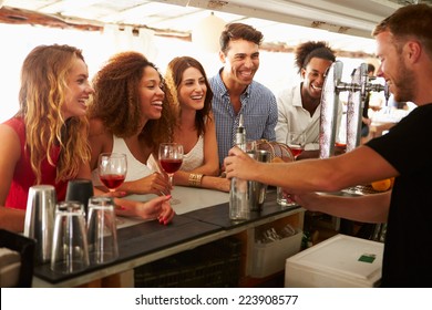 Group Of Friends Enjoying Drink At Outdoor Bar