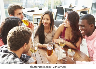 Group Of Friends Enjoying Drink At Outdoor Rooftop Bar