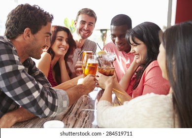 Group Of Friends Enjoying Drink At Outdoor Rooftop Bar