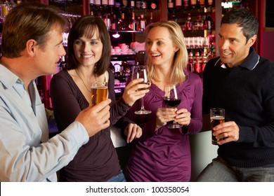 Group Of Friends Enjoying Drink Together In Bar - Powered by Shutterstock