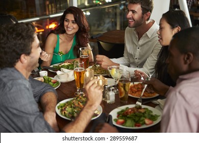 Group Of Friends Enjoying Evening Meal In Restaurant