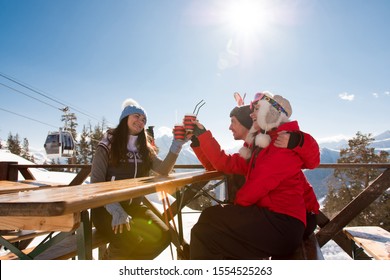 Group Of Friends Enjoying Hot Mulled Wine In Cafe At Ski Resort - Powered by Shutterstock