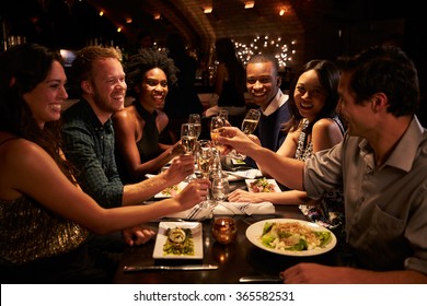 Group Of Friends Enjoying Meal In Restaurant