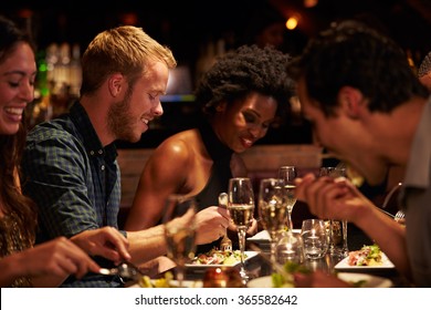 Group Of Friends Enjoying Meal In Restaurant