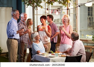 Group Of Friends Enjoying Outdoor Evening Drinks Party