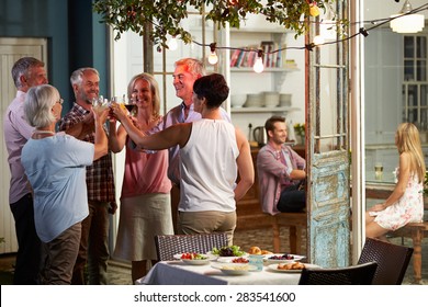 Group Of Friends Enjoying Outdoor Evening Drinks Party