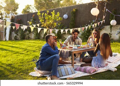 Group Of Friends Enjoying Outdoor Picnic In Garden