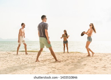 Group Of Friends Enjoying Playing Gliding Disc And Having Fun At The Beach On Summer Vacations