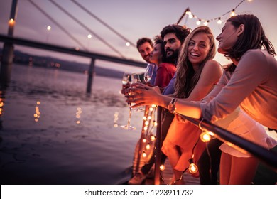 Group Of Friends Enjoying Sunset At The Party By The River