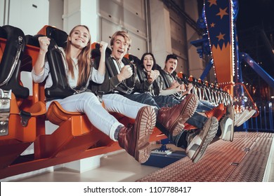 Group of friends enjoys in lunapark. Amusement park concept.