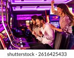 A group of friends excitedly celebrates a win at the slot machines in a colorful and dynamic casino environment. Their joyous expressions capture the thrill of the moment.