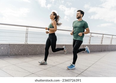 A group of friends exercises for cardio endurance, use a fitness watch and an app. Runners athletes in fitness clothes. Beautiful jogging in sports shoes. Motivation for a healthy lifestyle. - Powered by Shutterstock