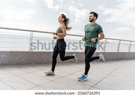 A group of friends exercises for cardio endurance, use a fitness watch and an app. Runners athletes in fitness clothes. Beautiful jogging in sports shoes. Motivation for a healthy lifestyle.