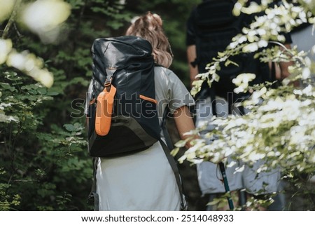 Group of friends exploring nature while hiking in a mountain forest, carrying backpacks and trekking equipment.