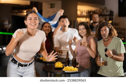 Group of friends fans watching match cheering with Scottish flag in bar - Powered by Shutterstock