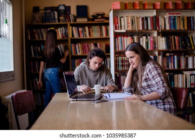 Group Of Friends Finding A Quiet Place In Univeristy Library For Studying.