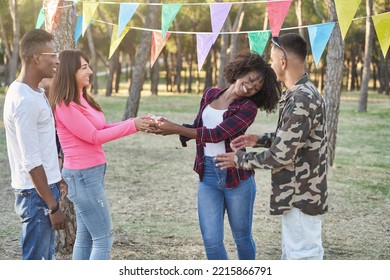 Group Of Friends Giving A Birthday Present To Their Friend While Having A Party Outdoors In A Park. Friendship Concept.