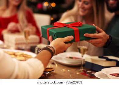 Group of friends giving Christmas presents at home - Powered by Shutterstock