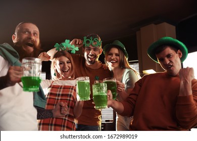 Group of friends with glasses of green beer in pub. St. Patrick's Day celebration - Powered by Shutterstock