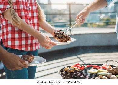 Group of friends having barbecue party on the roof - Shutterstock ID 701284750