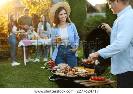 Group of friends having barbecue party outdoors. Space for text