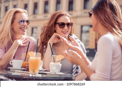 Group of friends having a coffee together. Three women at cafe, talking, laughing and enjoying their time. - Shutterstock ID 1097868269