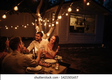 Group Of Friends Having Dinner In A Backyard