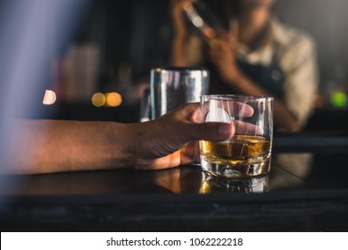 Group Of Friends Having Drinks Whiskey At The Night Club After Work . Young Men Drink Whiskey And Enjoying At A Bar Toasting Cocktails.