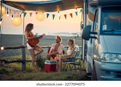 Group of friends having fun camping by the sea together - Powered by Shutterstock
