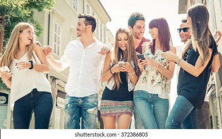 Group of friends having fun in the city center. Having fun and watching things on the smart phones - Powered by Shutterstock