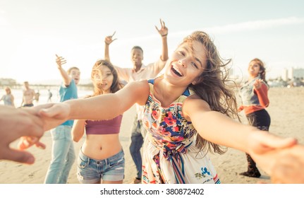 Group of friends having fun and dancing on the beach. Spring break party on the beach