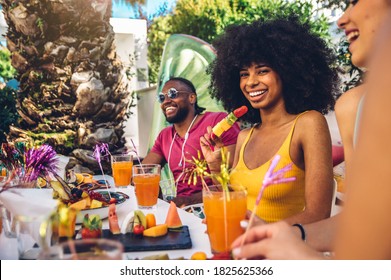 Group Friends Having Fun Drinking Cocktails Sitting In Villa Backyard - Happy Young Hispanic Woman Smiling At The Camera At Garden Party With Friends - Summer Lifestyle And Food Concept.