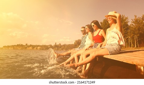Group of friends having fun near river at summer party. Banner design