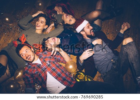 Group of friends having fun on a floor, celebrating New Year