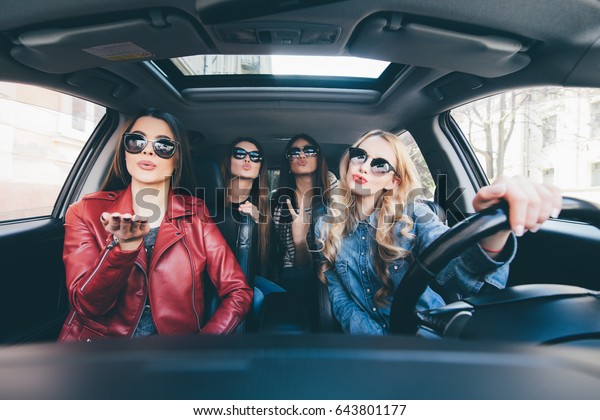 Group of friends having fun on the car. Singing\
and laughing in the city\
center