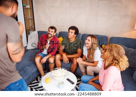Group of friends having fun playing pantomime while spending leisure time together at home