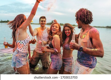 Group of friends having fun with powder paint outdoors - Powered by Shutterstock