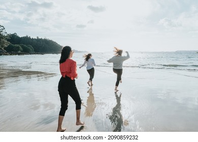 Group Of Friends Having Fun Running Along Winter Beach Together. Multi-ethnic. All Girls Club. Three Women Friends Laughing Together - Female Friendship Concept. Lifestyle. Freedom Travel Photography