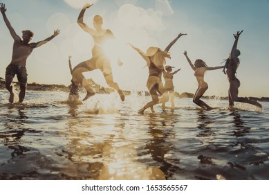 Group of friends having fun at the sea - Happy young people on a summer vacation at the beach - Shutterstock ID 1653565567