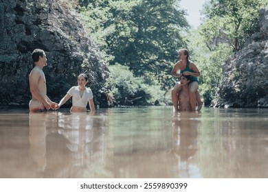 A group of friends having fun and swimming in a natural rocky stream surrounded by lush greenery. Perfect summer day scene full of laughter and relaxation. - Powered by Shutterstock