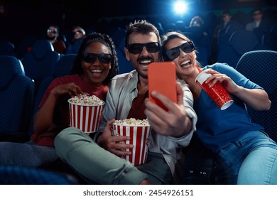 Group of friends having fun and taking selfie while watching 3D movie in cinema.  - Powered by Shutterstock